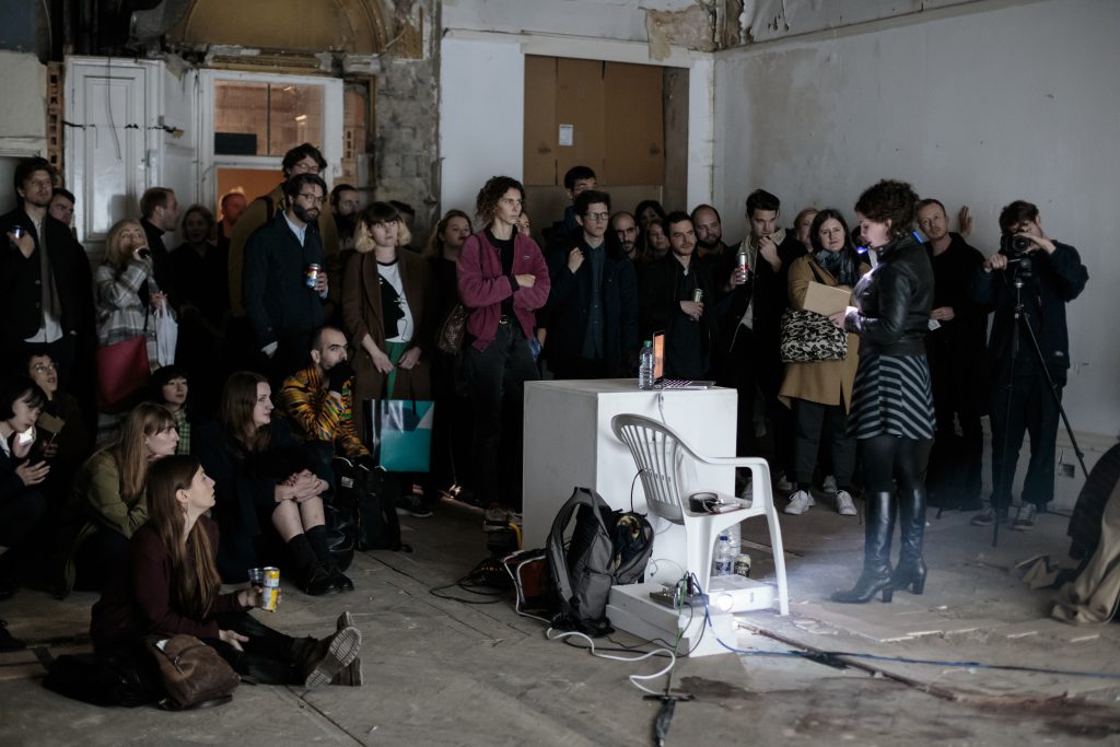 Sarah Gillett standing in front of an audience delivering a story show