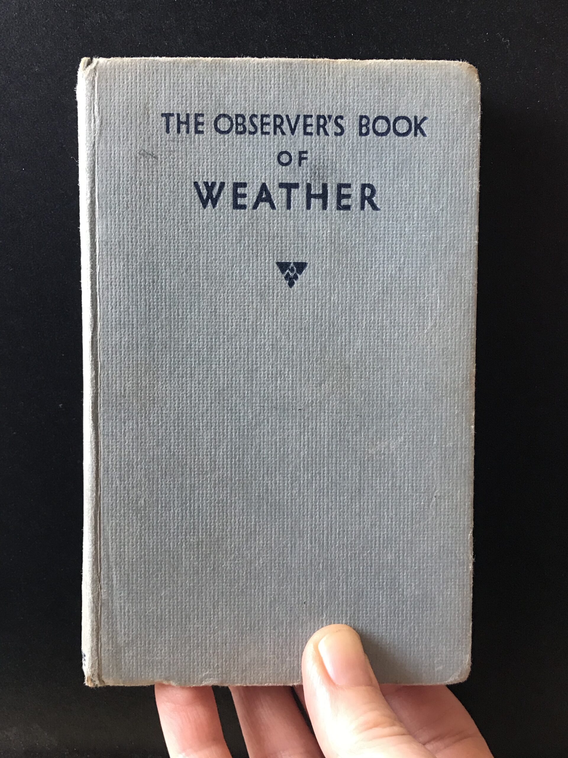 Through a glass, darkly: Hand holding The Observer Book of Weather