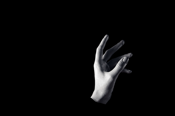 Sturgeon: A white painted left hand reaches up out of a black darkness as if from a lake at night