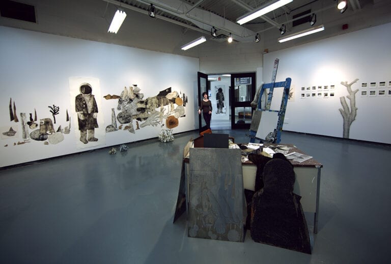 So pass away the old timers, one by one: view of a gallery with an installation in the middle of a room of an artist's desk