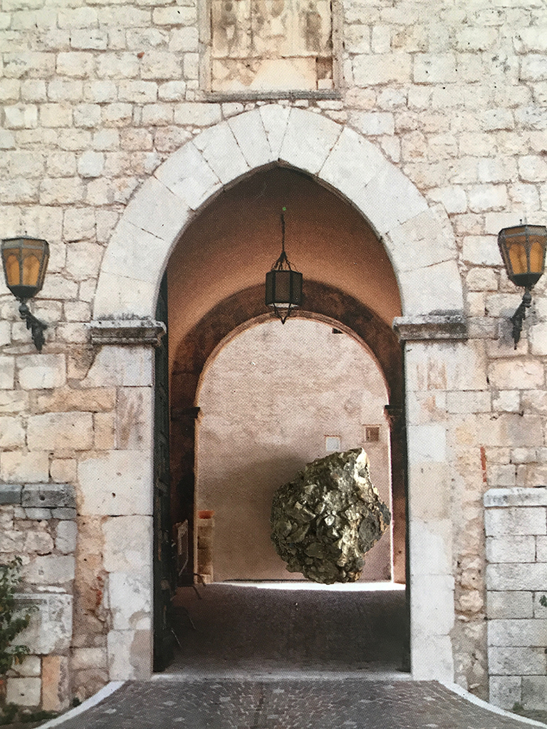 Tourist: a meteorite poses against a pale stone building, seen through an arch